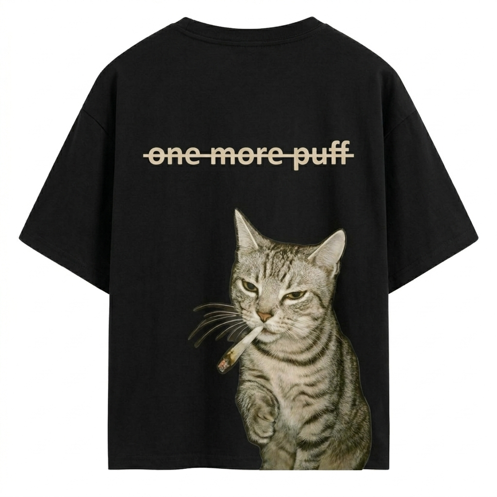 Black AKIDO oversized 100% pure cotton graphic t-shirt featuring a realistic smoking cat illustration and “One More Puff” text print on the back in trendy streetwear style.