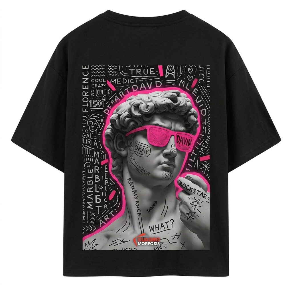 "Rear view of a male model wearing a black Akido oversized streetwear t-shirt featuring a large graphic print on the back. The graphic displays a grayscale statue of Michelangelo's David wearing vibrant neon pink sunglasses, surrounded by white graffiti text, doodles, and a pink neon outline, set against a concrete wall backdrop."